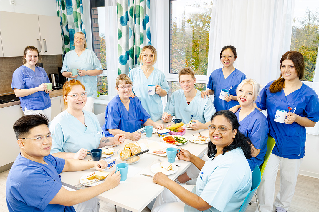 Gruppenbild von Pflegekräften in der Atemzeit Einrichtung. Alle sind beim gemeinsamen Frühstück
