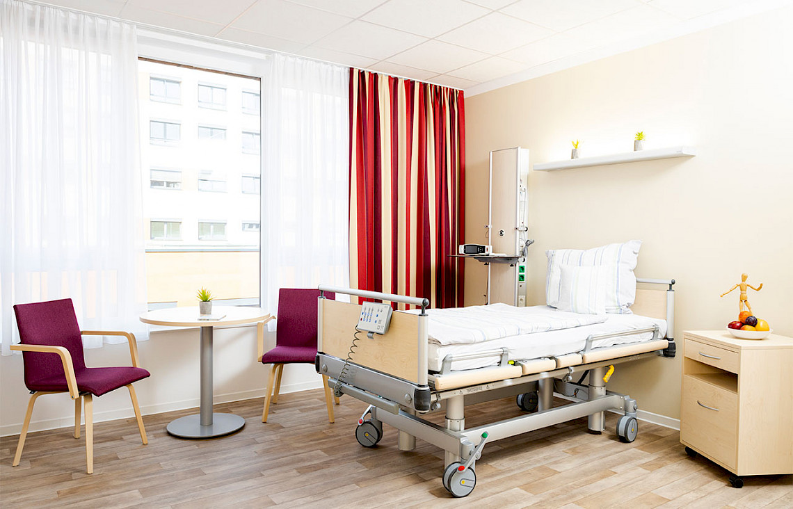 Bild zeigt ein Bewohnerzimmer, das für die Intensivpflege komplett ausgestattet ist, z.B. mit einem Sättigungsgerät und trotzdem wohnlich escheint