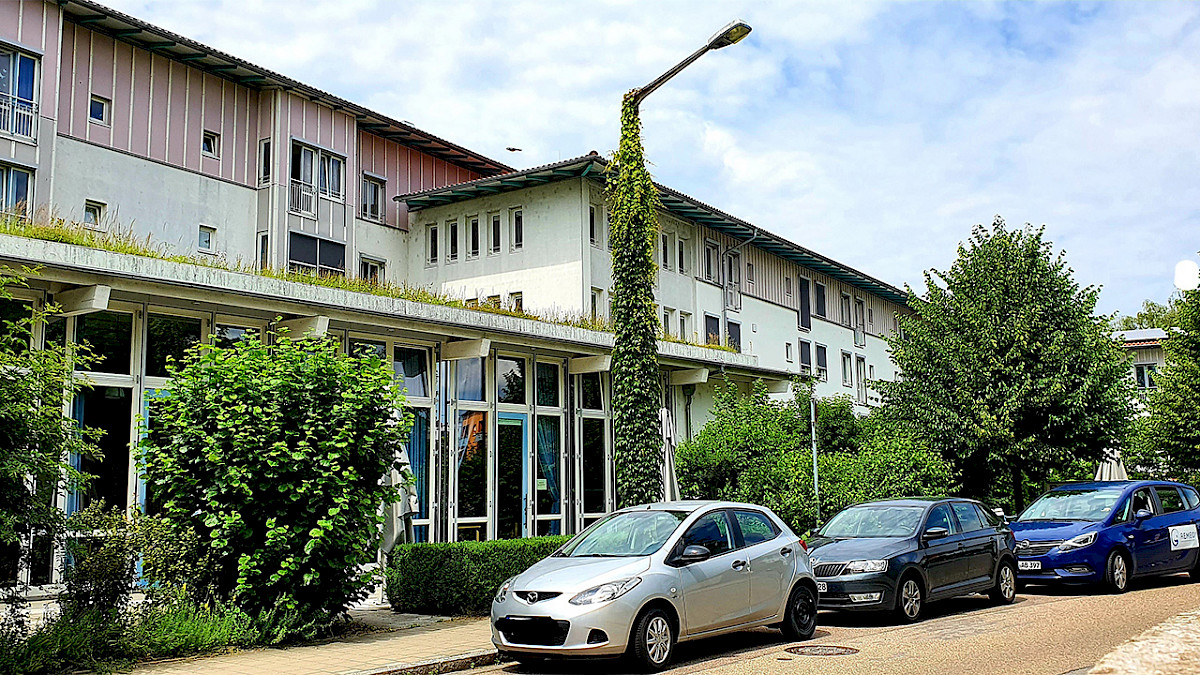 Ansicht des Gebäudes von außen. Es sind auch Bäume zu sehen.